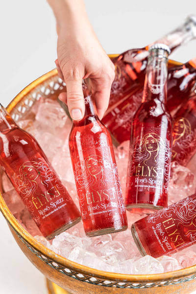 Élyse-Gastropartner nimmt Élyse Rosé-Sprizz (Élyse Rosé-Spritzer)-Flasche aus Champagnerkühler